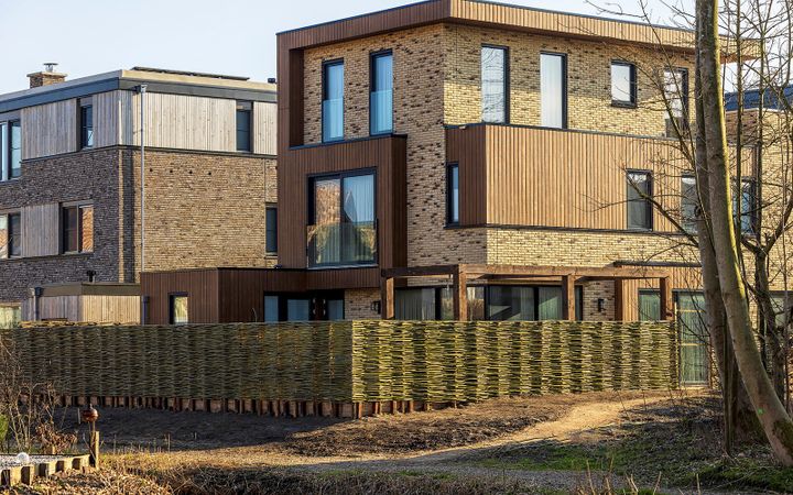 Wilgentenen schuttingen rondom een moderne villa