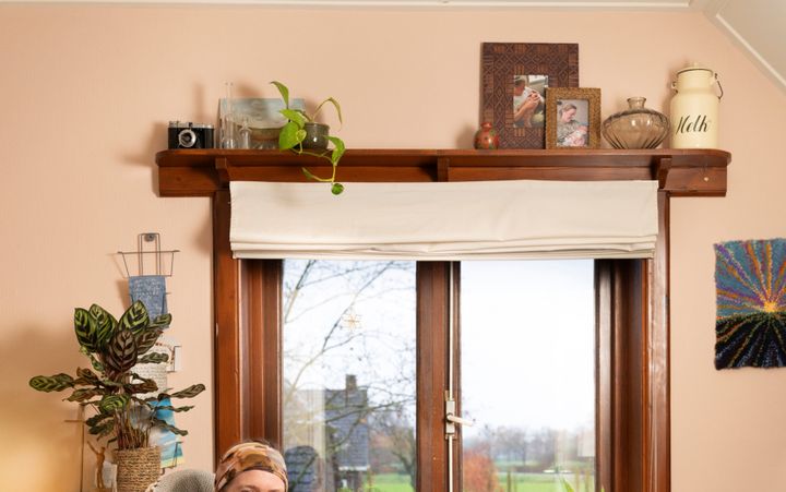 Een jonge vrouw zit op een stoel in een woonkamer.