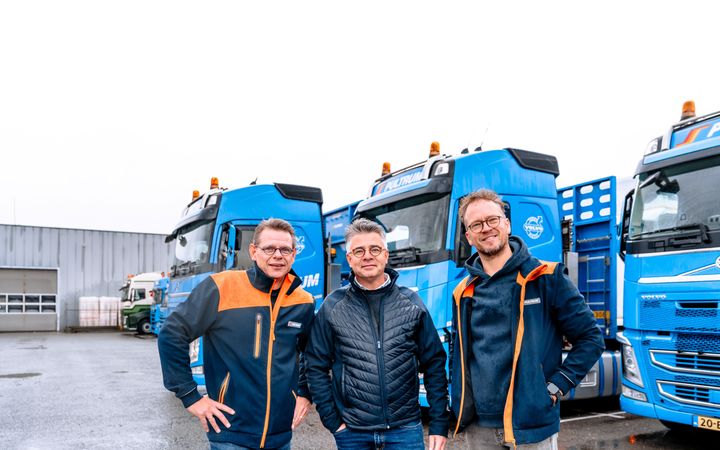 Marcel, Eelco en Gert-Jan (v.l.n.r.) staan voor de blauwe vrachtwagens van Pultrum, waar ze als hobby op rijden.