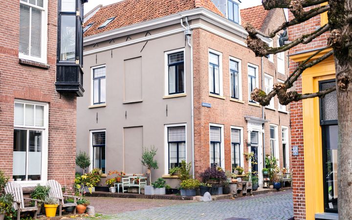 Monumentale huizen, met op de stoep tuinbankjes en veel plantenbakken.