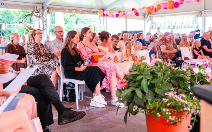 Een groep mensen zittend op witte st