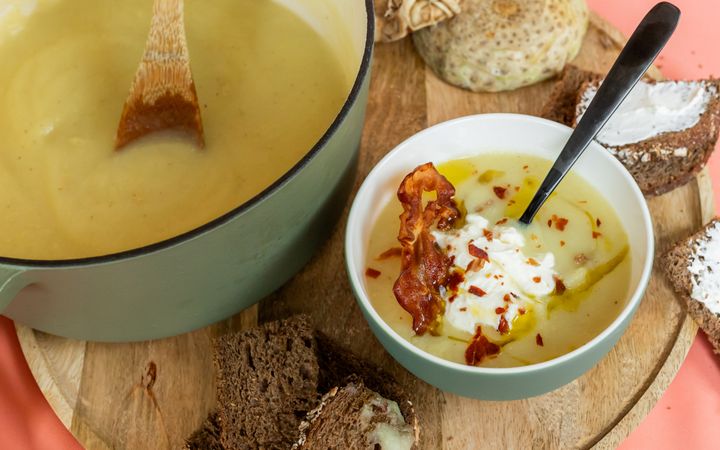 Een pan en een kom met soep, en brood.