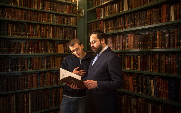 Student Asher in gesprek met studentenrabijn Yanki Jacobs in de eeuwenoude bibliotheek van de Portugese Synagoge in Amsterdam.