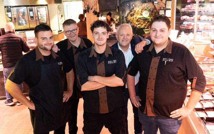 Vijf mannen in een verswinkel.