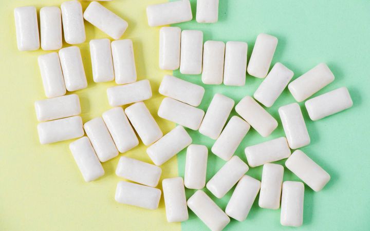 Witte kauwgom tegen een geel-groene achtergrond