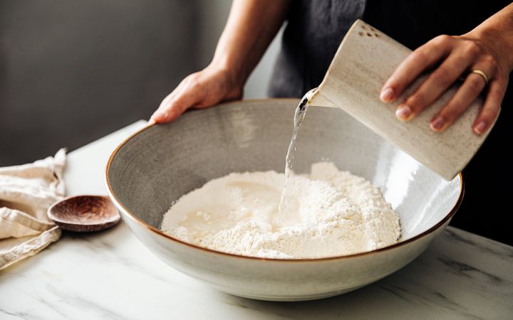 schaal met bloem waar water bij wordt gegoten