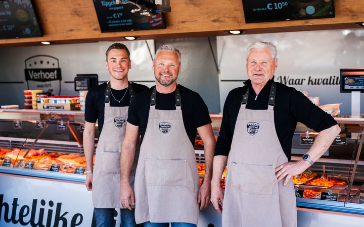 Drie generaties poeliers Verhoef staan voor de vitrine van hun polierswagen.  V.l.n.r.: Philip junior, Gert-Jan en Philip senior.