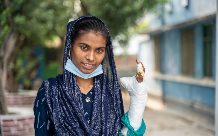 Portretfoto van een jonge vrouw met haar hand in het gips