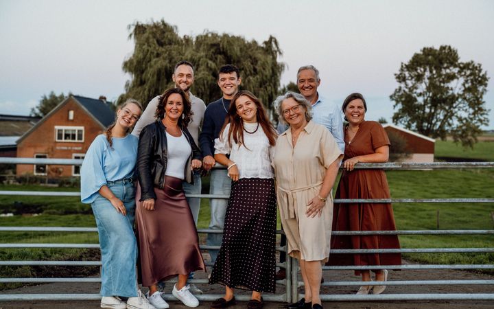De familie Colijn poseert voor een hek bij een weiland. V.l.n.r. voorste rij: Anne-Co, Jacomien, Jet, Willemieke. Daarachter v.l.n.r.: Jaap, Job, Hendrik-Jan en Lianne.